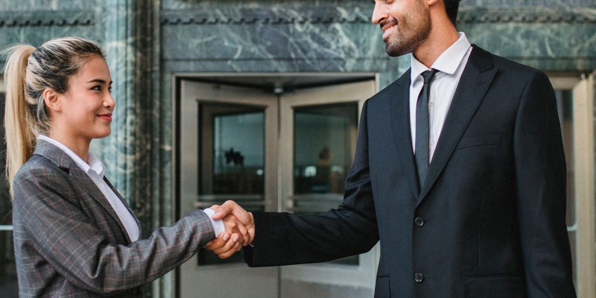 Two professionals shaking hands, symbolizing successful business partnerships and growth strategies in the AI market.