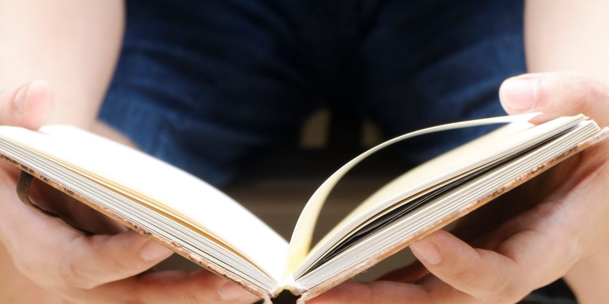 A person intently reading, symbolizing the strategic absorption of information amidst a vast amount of data.