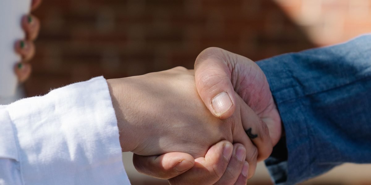 Two professionals shaking hands, symbolizing a successful negotiation or a new career opportunity.