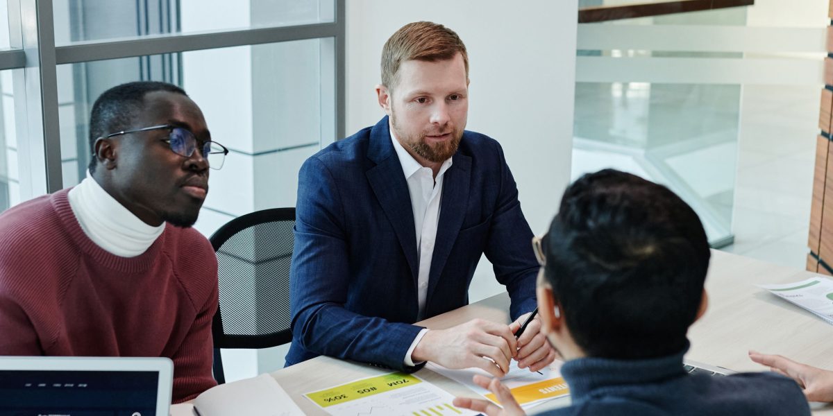 A group of investors intently reviewing financial charts and discussing market trends.