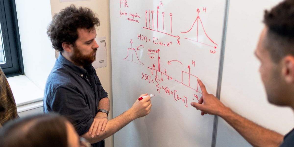 A diverse team collaborating on a whiteboard, brainstorming and developing innovative solutions.