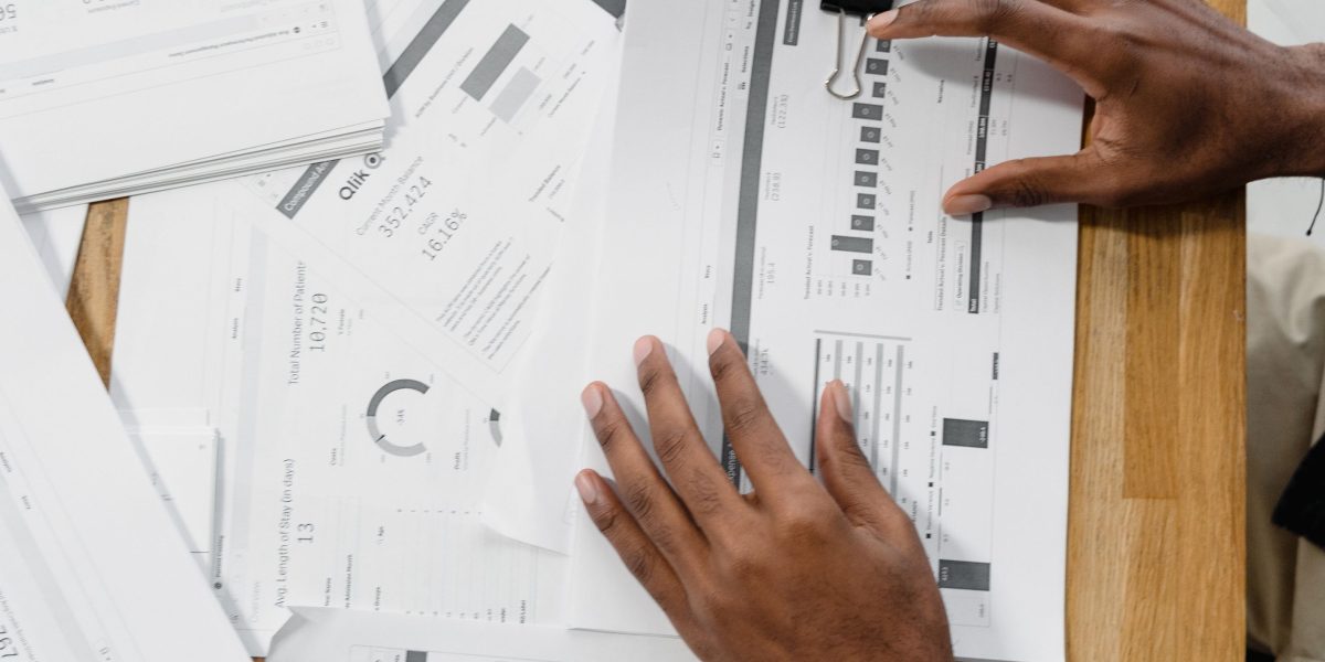 An individual thoughtfully examining reports to derive actionable insights for business strategy.