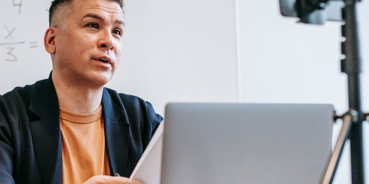 A professional engaged in an online course or reading on a tablet or laptop, focusing on continuous learning and skill development.