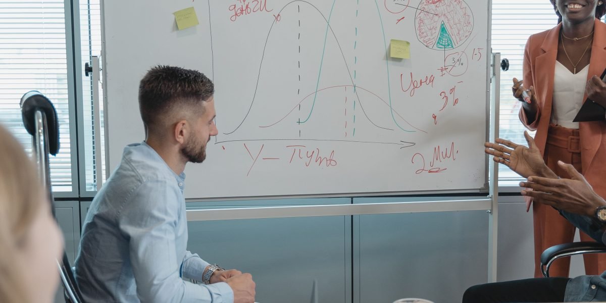 An executive or manager explaining a strategy on a whiteboard, embodying leadership in data and AI initiatives.